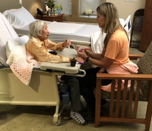 A volunteer visiting with a patient at Peggy