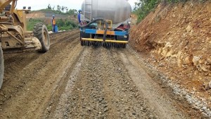 A water cart applies soil stabilizer RT20 for long-term strengthening of a road being upgraded