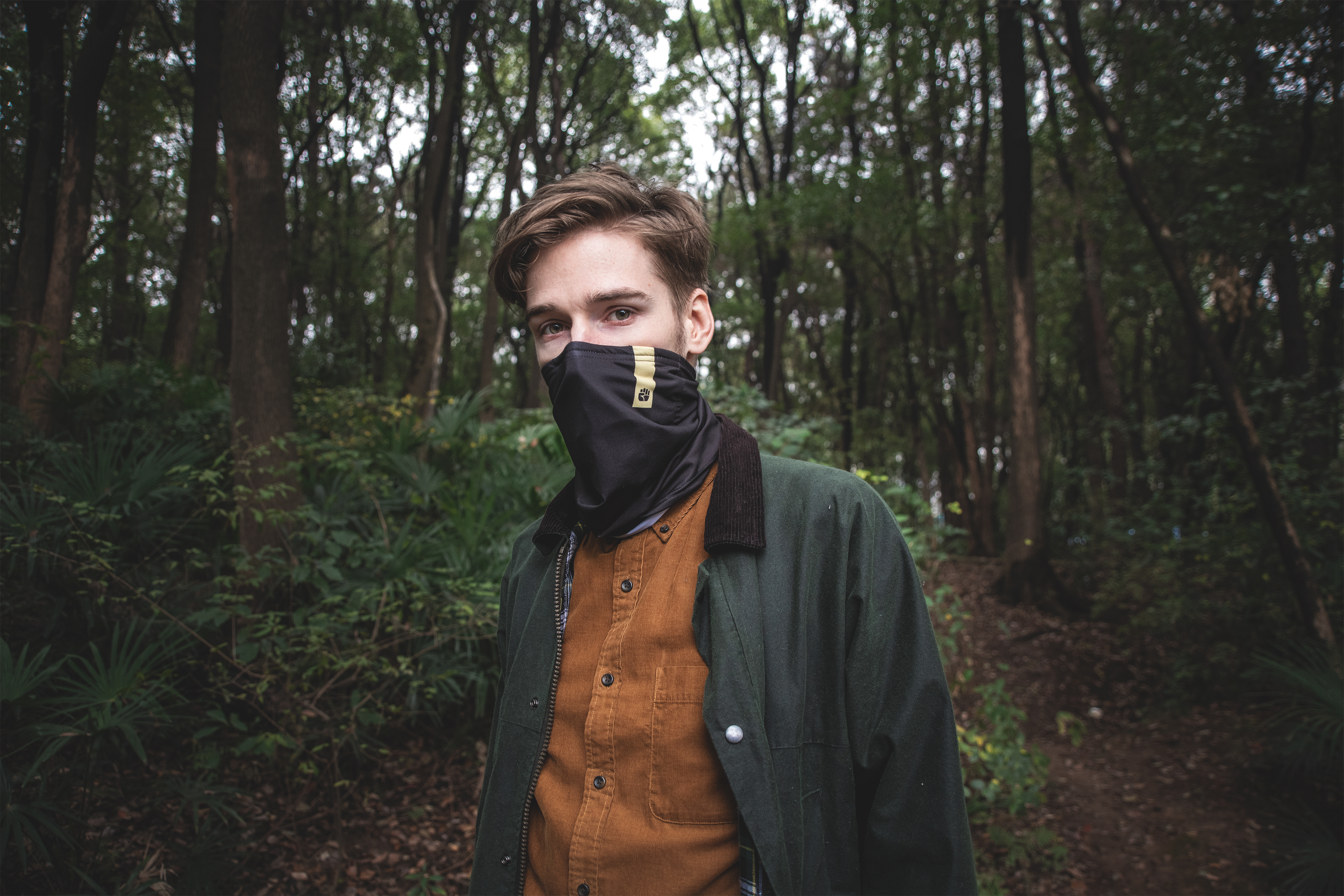 Male wearing scarf hiking in the woods Male wearing scarf hiking in the woods