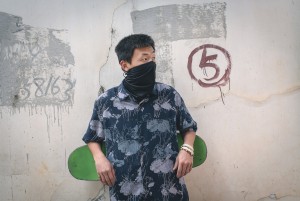 Male wearing scarf with his skateboard