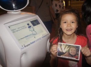 Promobot printing photo for young girl at Commonwealth Games