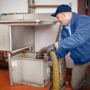 A serviceman Cleaning Grease Trap