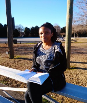 Author Angel S. Broady portrait photo of her reading a book at the park.
