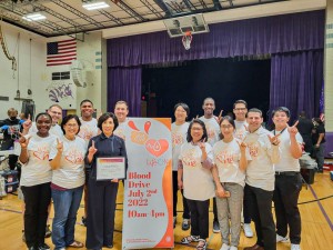 NHNE leaders pose with a sign for victory for a successful event