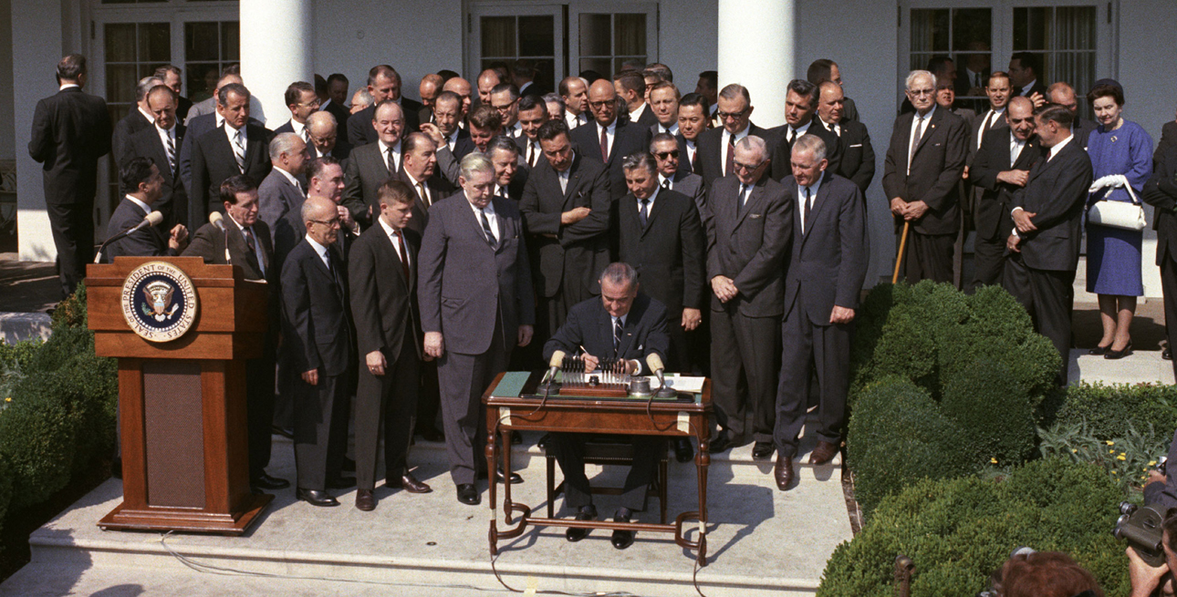 President Lyndon B. Johnson signs the Economic Opportunity Act