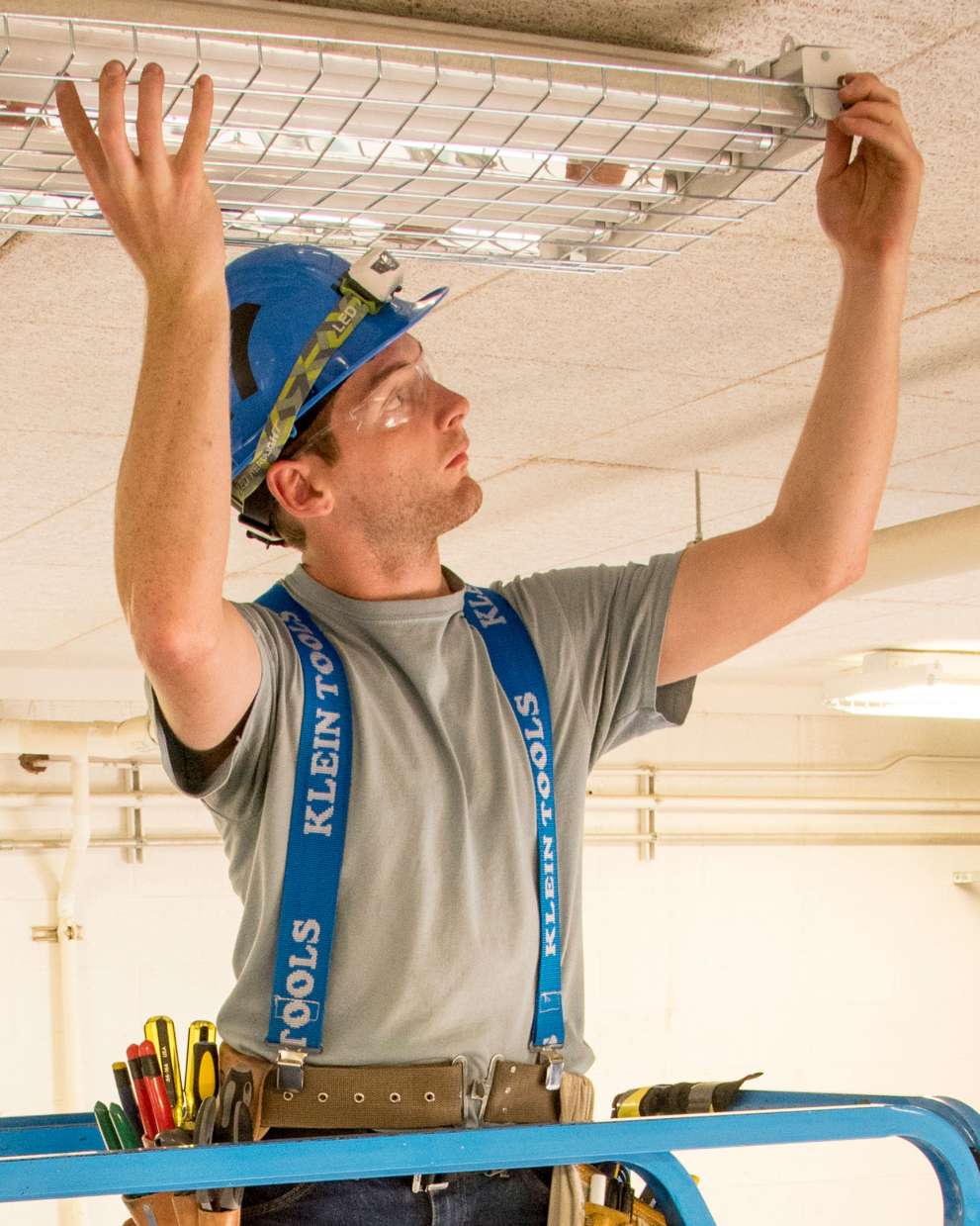 Careers Page Sign, Billboard, and Display Background Image A Sign, Billboard, and Display worker installs a sign in a hallway