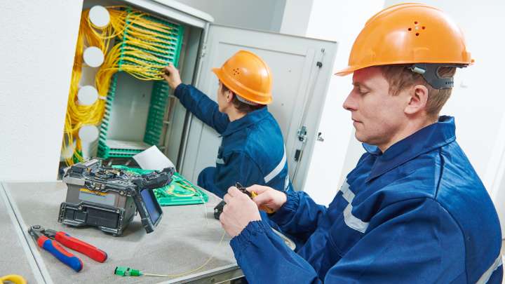Careers Page Sign, Billboard, and Display Background Image A Sign, Billboard, and Display worker installs a sign in a hallway