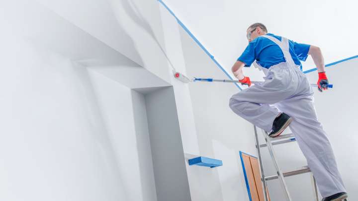 Careers Page Sign, Billboard, and Display Background Image A Sign, Billboard, and Display worker installs a sign in a hallway