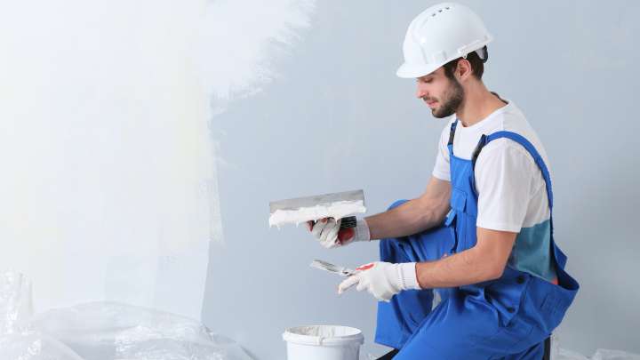 Careers Page Sign, Billboard, and Display Background Image A Sign, Billboard, and Display worker installs a sign in a hallway
