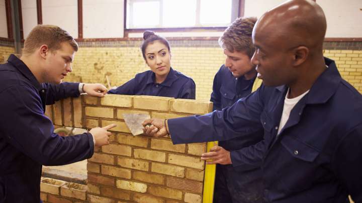 Careers Page Sign, Billboard, and Display Background Image A Sign, Billboard, and Display worker installs a sign in a hallway