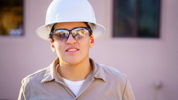 Careers Page Sign, Billboard, and Display Background Image A Sign, Billboard, and Display worker installs a sign in a hallway