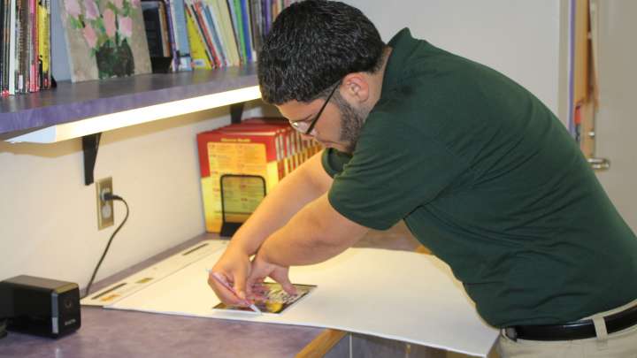 Careers Page Sign, Billboard, and Display Background Image A Sign, Billboard, and Display worker installs a sign in a hallway