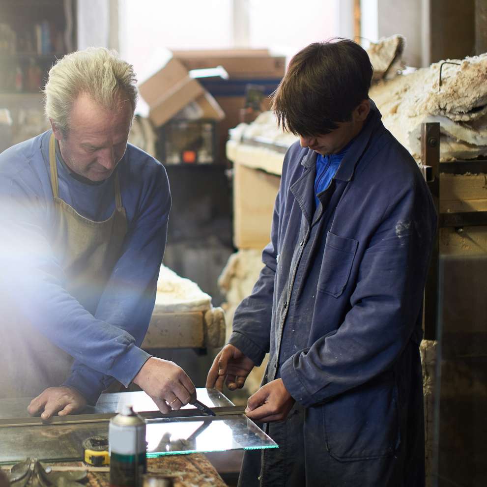 Careers Page Glazing Background Image A glazier measures a piece of glass.