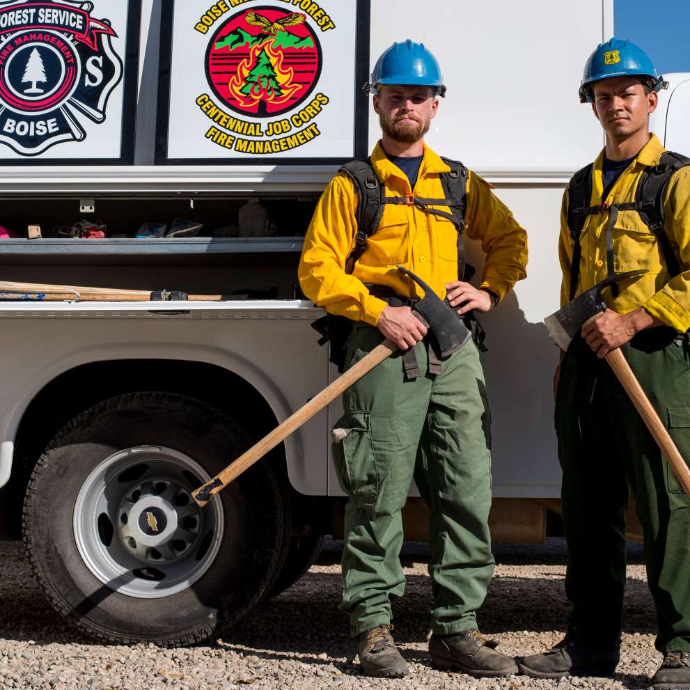 Wildland firefighters stand with firefighting gear