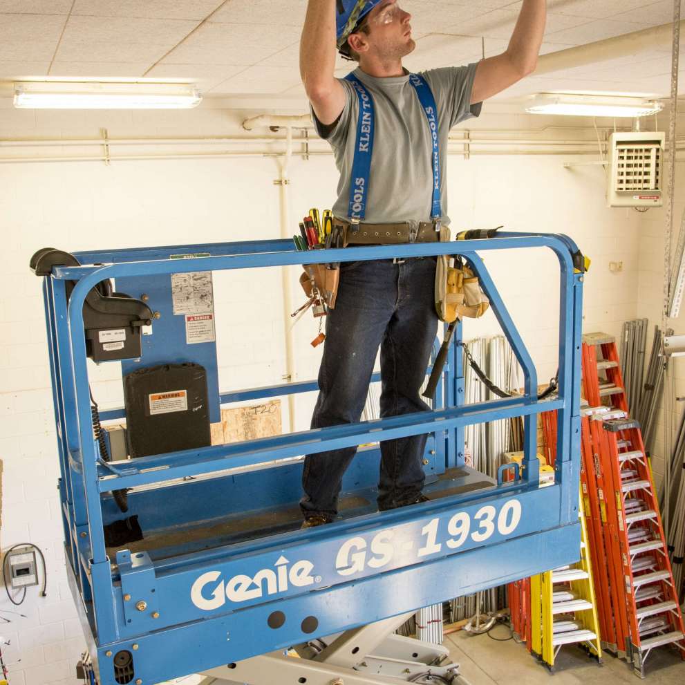 Careers Page Sign, Billboard, and Display Background Image A Sign, Billboard, and Display worker installs a sign in a hallway