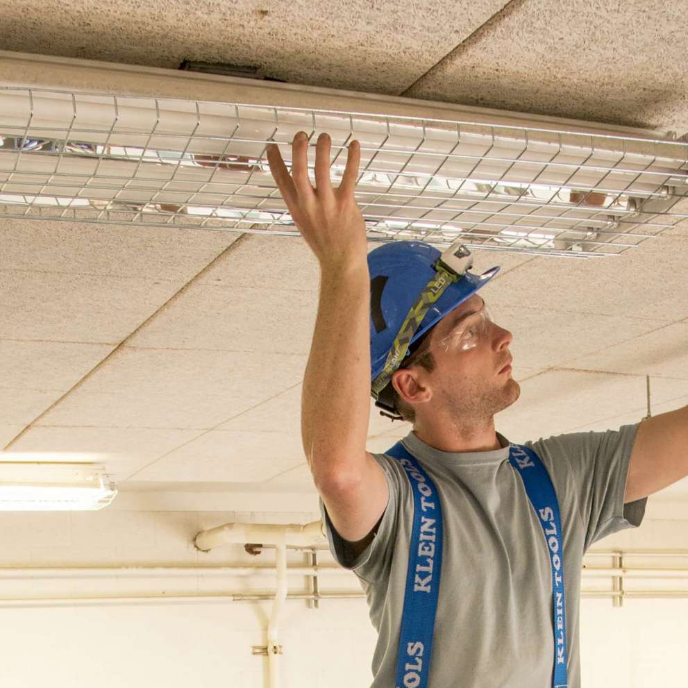 Careers Page Sign, Billboard, and Display Background Image A Sign, Billboard, and Display worker installs a sign in a hallway
