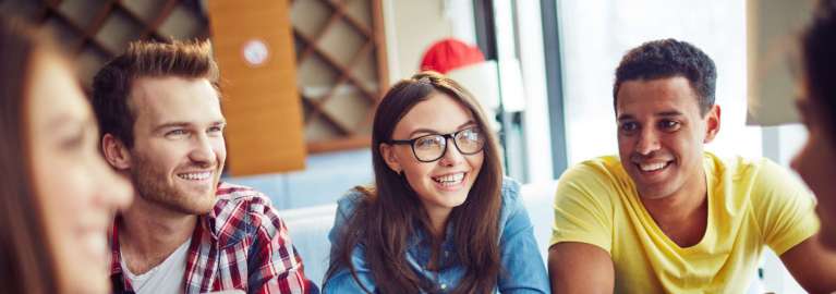 students sitting at a table smiling