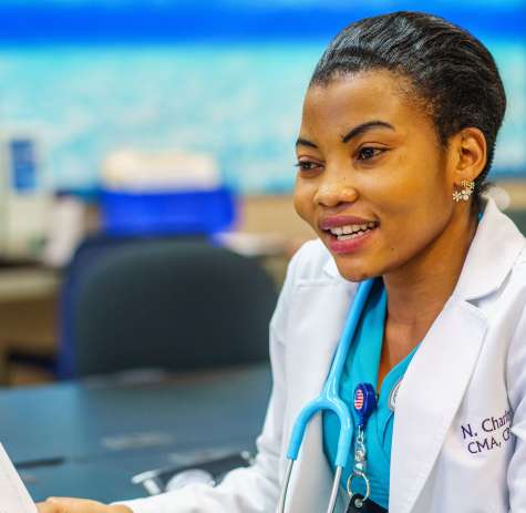 A clinical medical assistant listens to a patient.