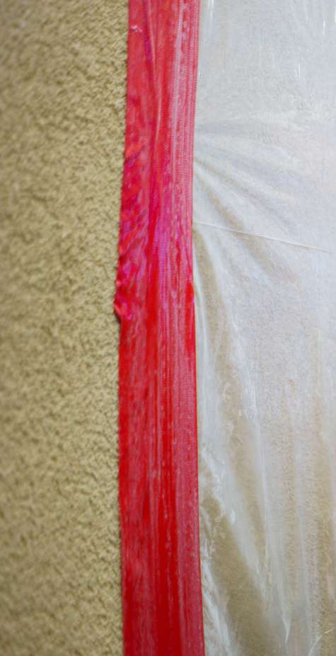 A plastering technician applies a coat to a wall.