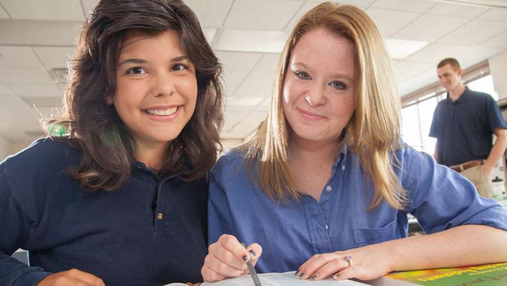 For Citizens About Job Corps Page Image Two Job Corps students sitting at a table, studying and smiling
