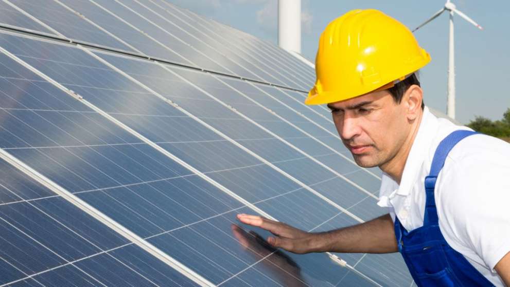 For Citizens American Recovery and Reinvestment Act Page Image A worker in a hard hat inspects a PV solar installation.