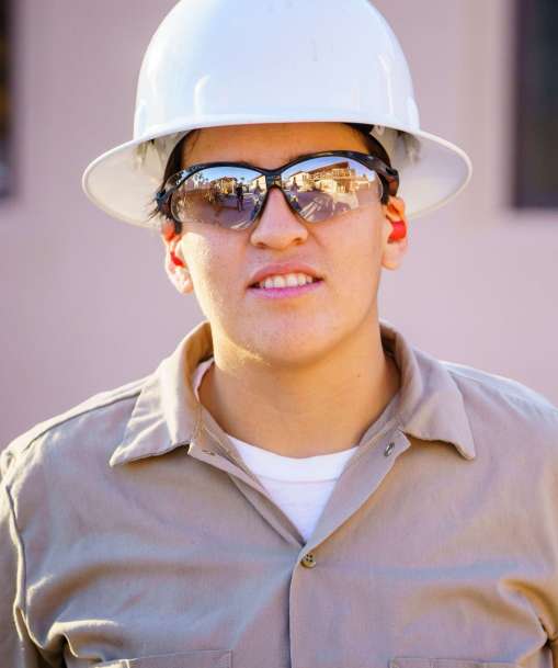 A Job Corps student wearing a hard hat and eye protection
