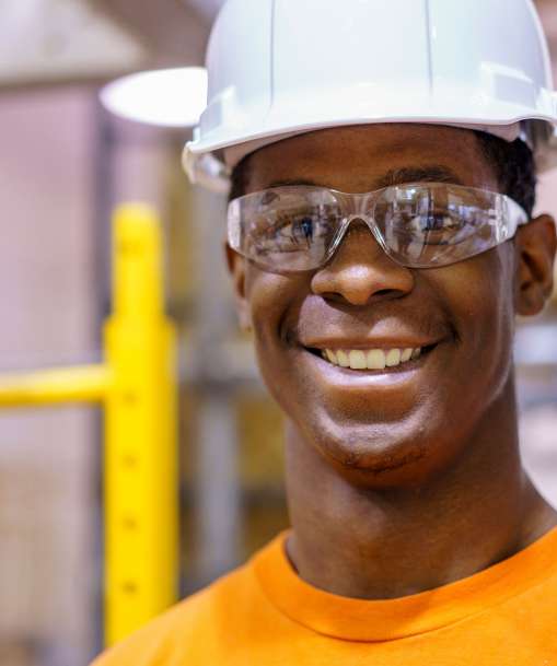 A Roustabout Operator turns a valve wheel at a refinery