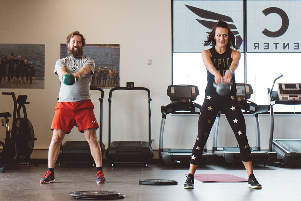 Female wearing Epic AF tank while doing a kettlebell swing