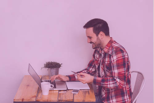 Hombre joven revisando su score crediticio en su computadora para aumentar su linea de crédito