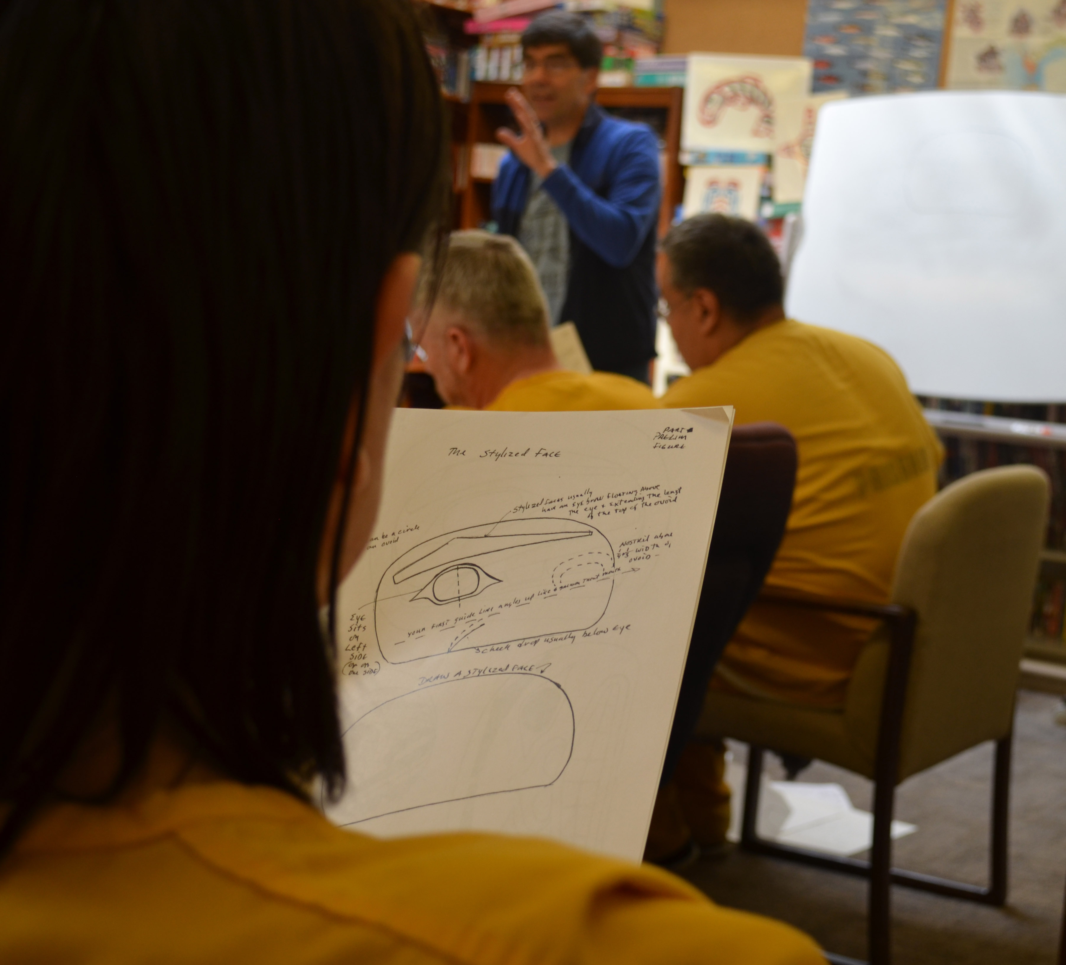 Littlefield examines one of David A. Boxley's handouts. He says handouts like these, and Boxley's ability to break things down make him a great teacher. (Photo by Scott Burton/KTOO)