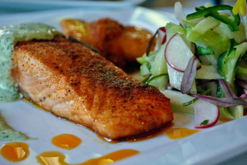 The Savory Street International Cafe in Sarasota, Florida, serves this ancho pepper crusted filet of salmon with a cilantro crema and a tomatillo, chayote, radish salad.