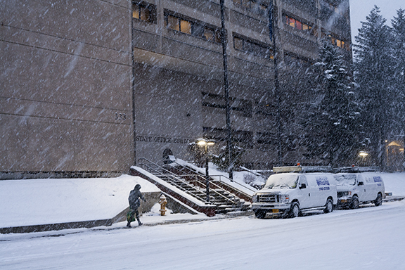 A pedestrian walks into the State Office Building in downtown Juneau on Monday, Feb. 26, 2018. (Photo by Tripp J Crouse/KTOO)