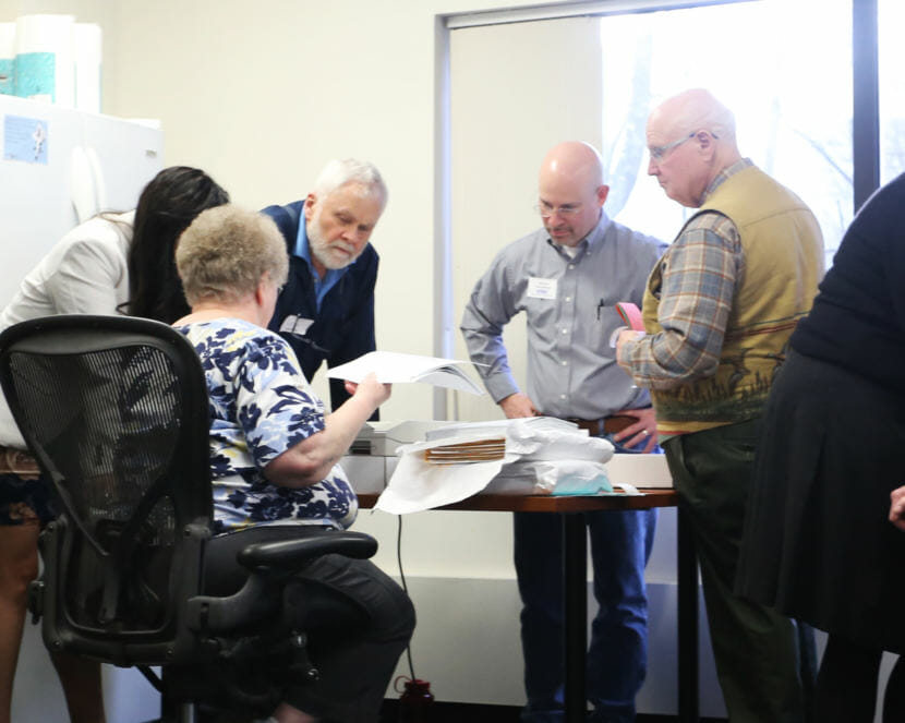 Official observers representing House District 1 candidates Bart LeBon and Kathryn Dodge watch the recount process at the Alaska Division of Elections office in Juneau on Nov. 30, 2018.