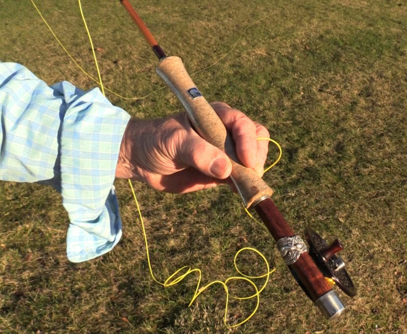 A silver spoon with the image of goddess Minerva on a Hawaiian background serves as a reel cup on one of Jon Lyman's handcrafted bamboo fly rods.