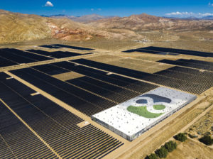 Image of rendering of large solar farm and battery storage units with mountain range in background.
