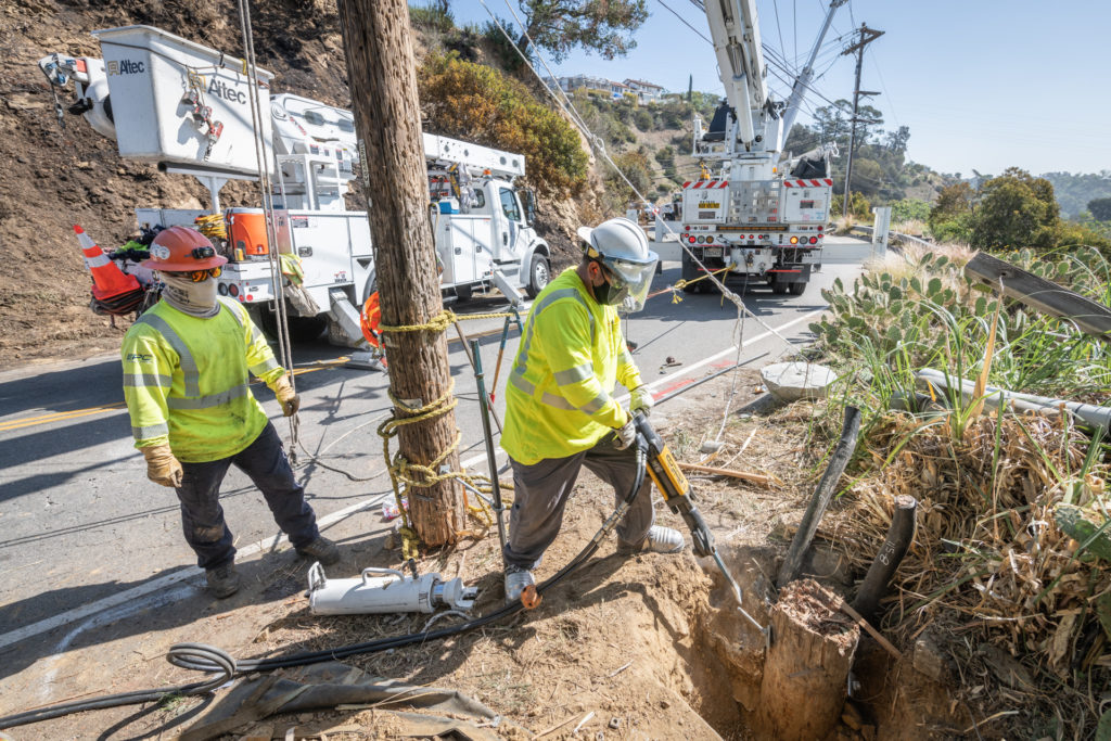 Crews making repairs to stump on hillside.