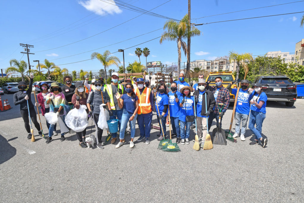 Image of a group of people with trash bags and brooms