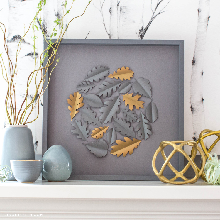 gray and gold papercut home decor on shelf with plant and other ornaments