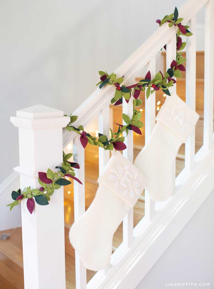 felt greenery garland on staircase banister with white stocking