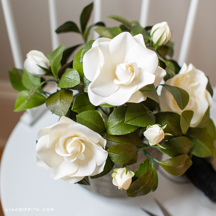 white crepe paper gardenia plant on white chair