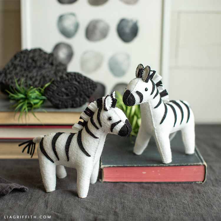 felt zebra stuffie friends near books and wall art