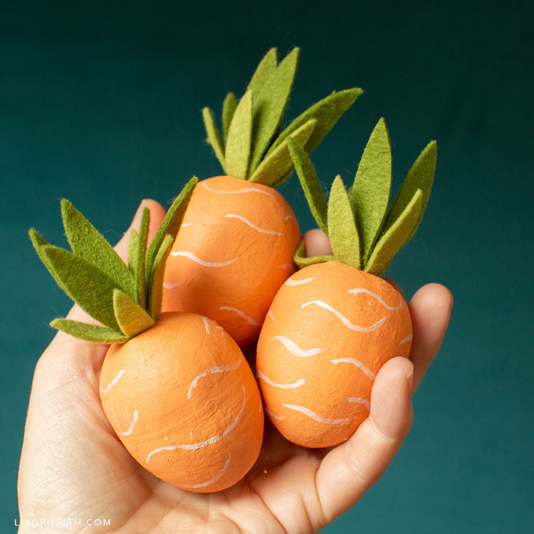 hand holding carrot Easter eggs