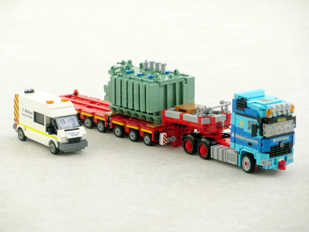 A large truck carrying a transformer and its escort van