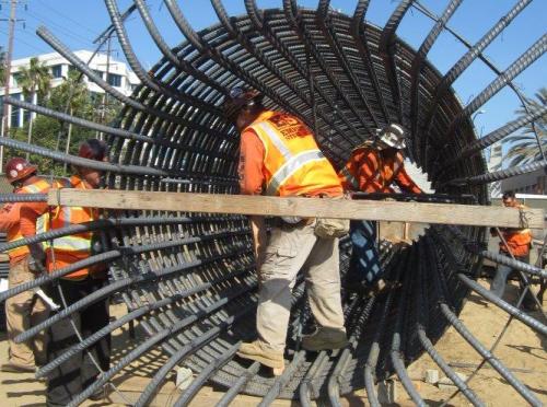 Trabajadores de la construcción trabajan en la armazon de lo que será una columna para el puente en Olympic Boulevard.
