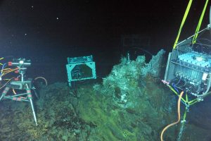 During ROPOS Dive R1729, a digital-still camera (left), a mass spectrometer (middle) and a fluid- and microbial-DNA sampler (right) were installed in the International District Hydrothermal Field at the vent called El Gordo. A titanium "hat" rests on top of the structure in a tubeworm and limpet patch. Inside the "hat" are temperature probes and intake nozzles for the fluid and DNA sampler. Photo credit: NSF-OOI/UW/CSSF; Dive R1729; V14.