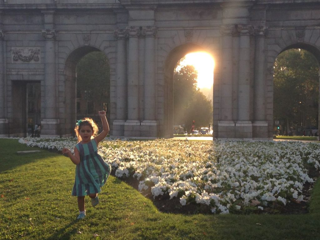 Girl running through Plaza de la Independencia in Madrid