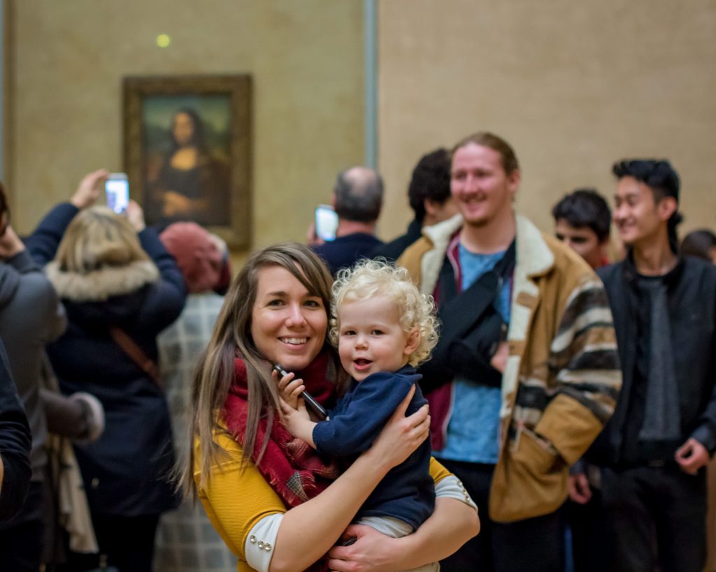 Mother and son view Mona Lisa in the Louvre