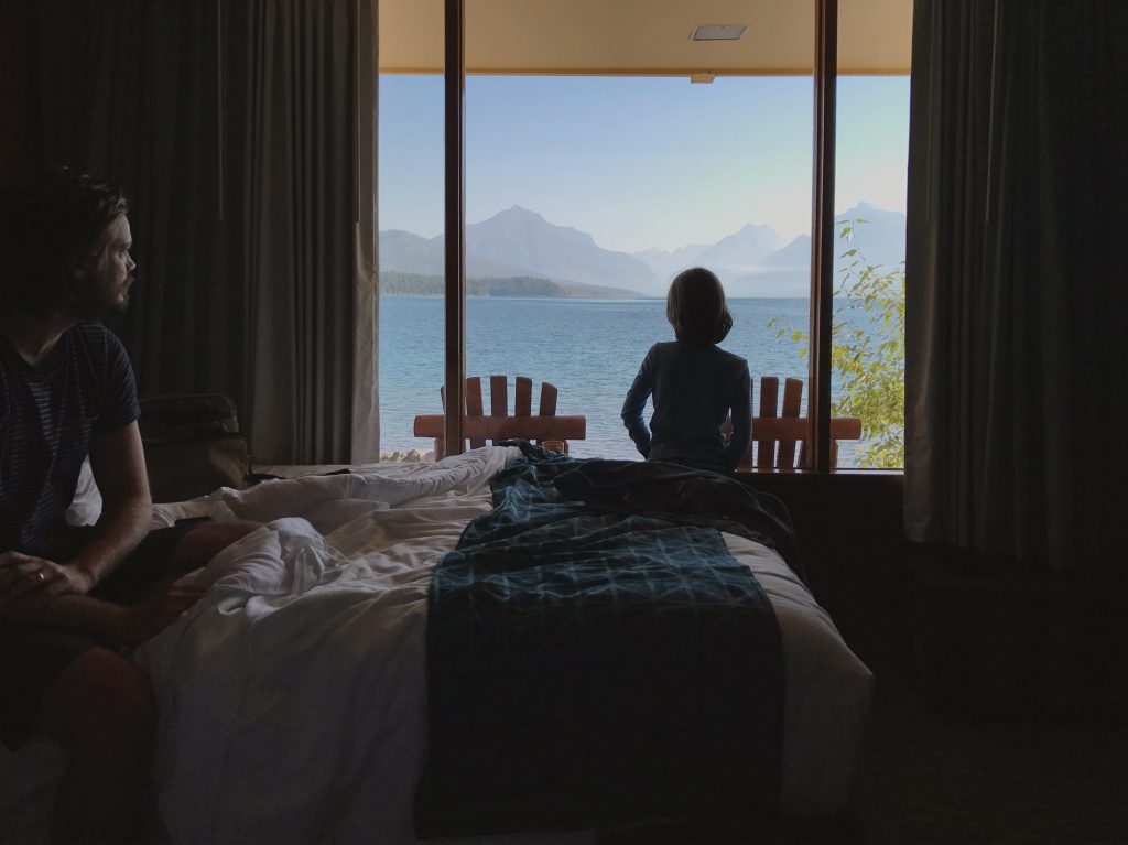 Boy looking out the window of hotel in Glacier National Park