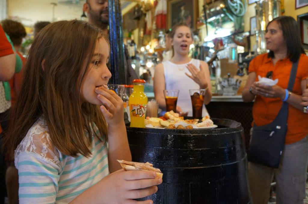Girl tasting food on food tour in Madrid