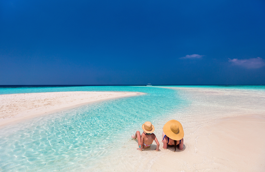 Family relaxing on beach in Maldives